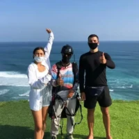 a paragliding instrucor with two guests